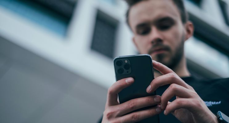 jeune adulte comparant les offres de mutuelle jeune sur son téléphone